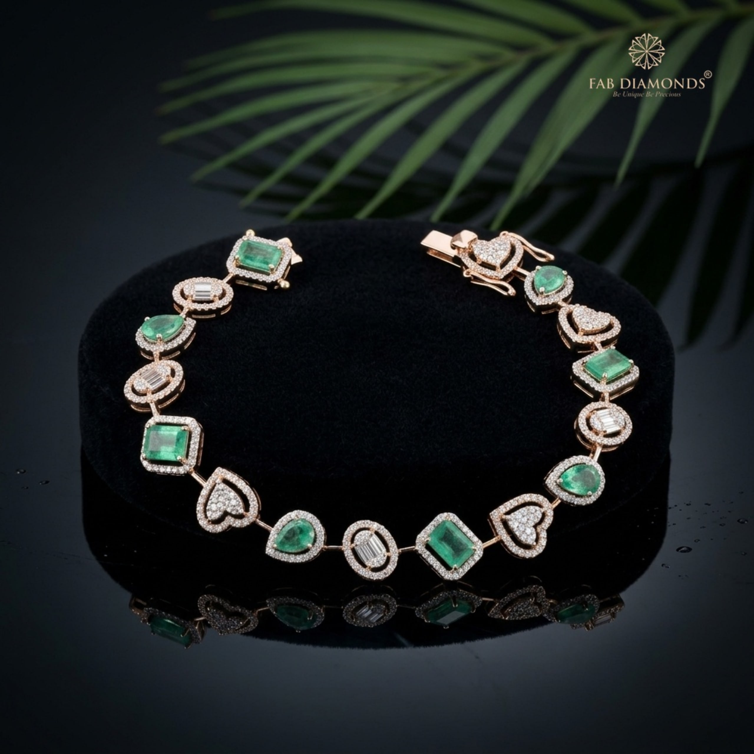 An 18KT gold station bracelet with emerald-cut and pear emeralds and diamond hearts
