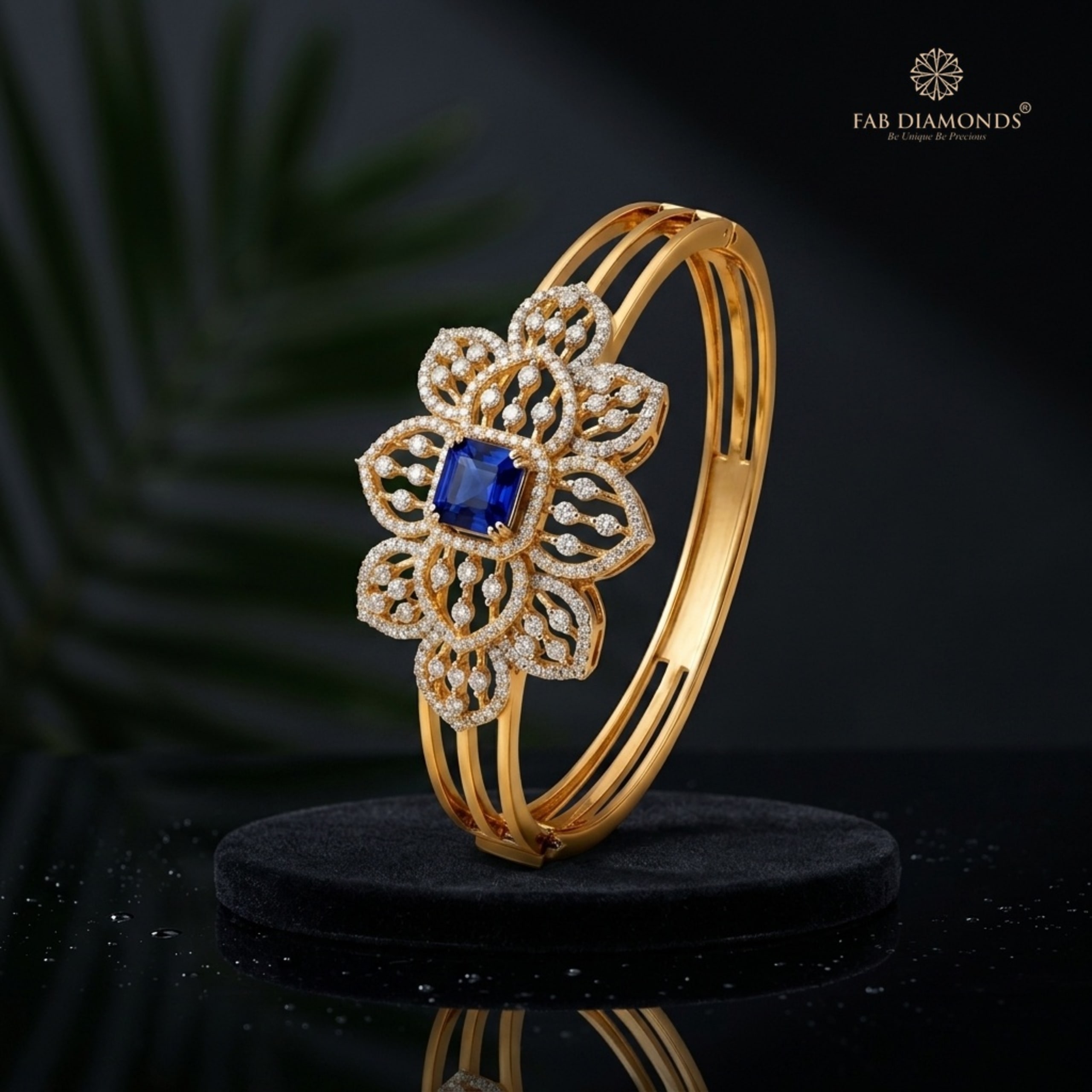 An 18KT yellow gold cuff with a diamond lotus mandala and royal blue sapphire center