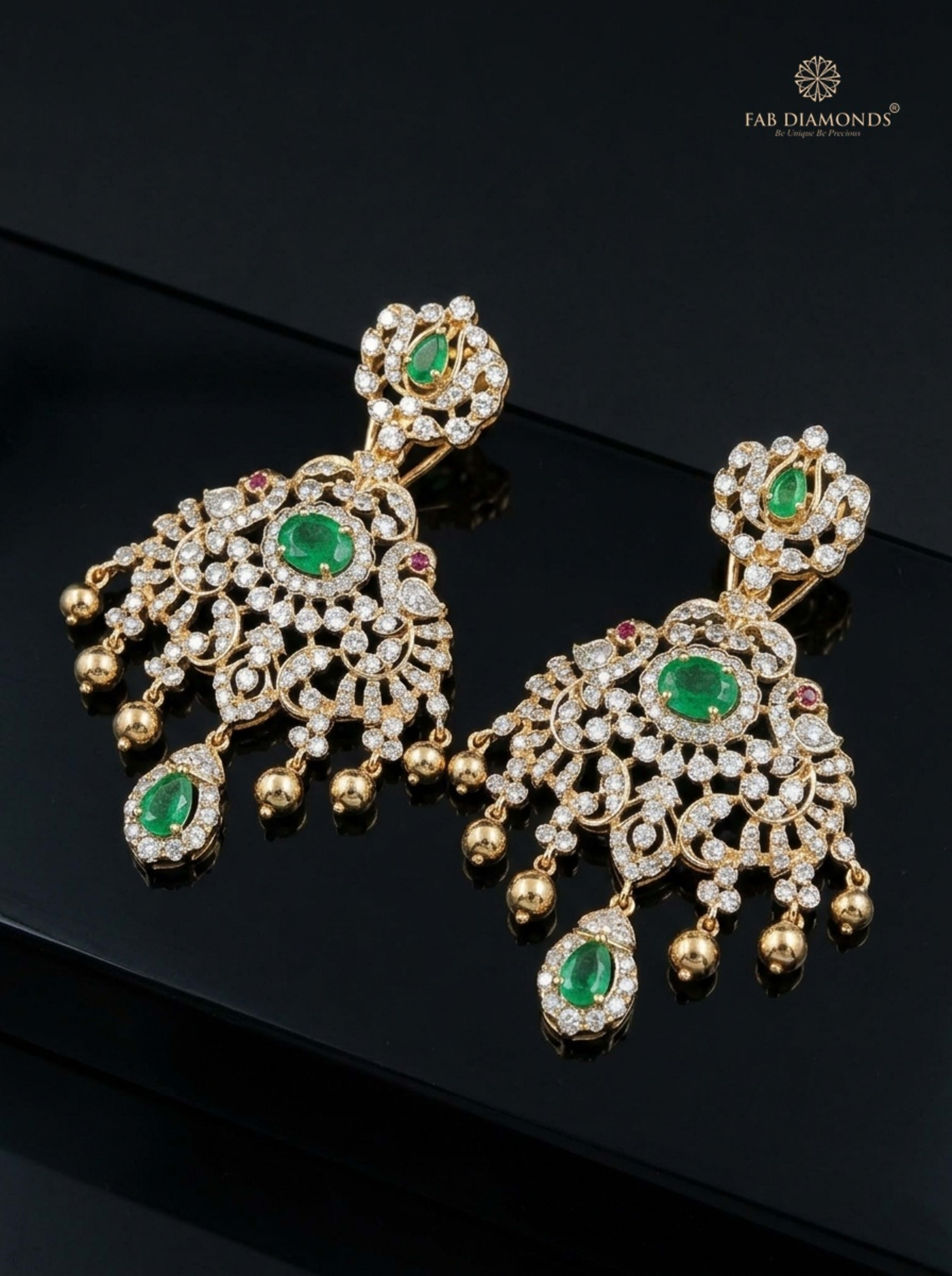 Emerald and Diamond Arabesque Chandelier Earrings on charcoal stone pedestal