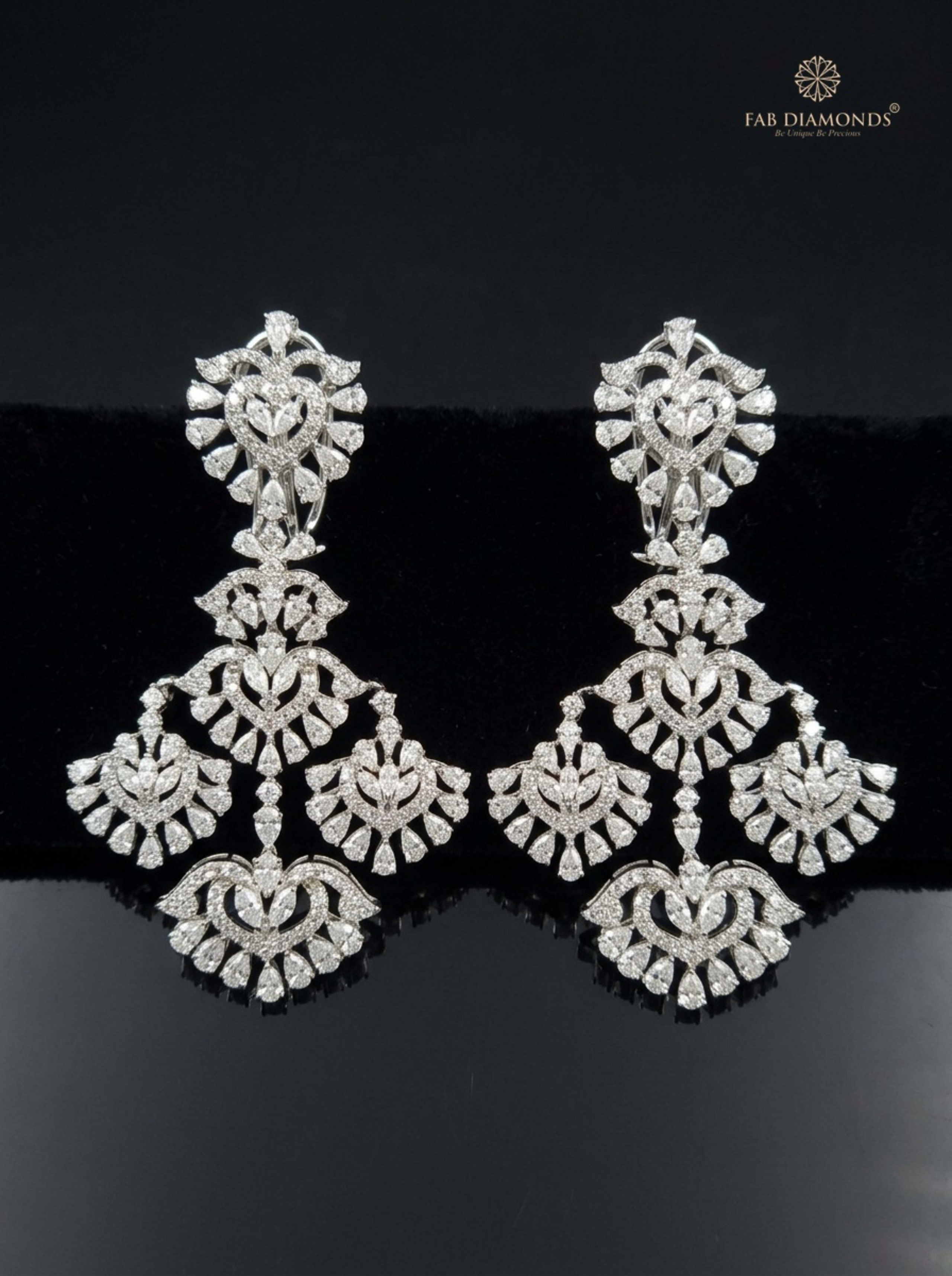 Pear Emerald, Scrolled Ribbon and Pink Pota Drop Earrings on matte black surface