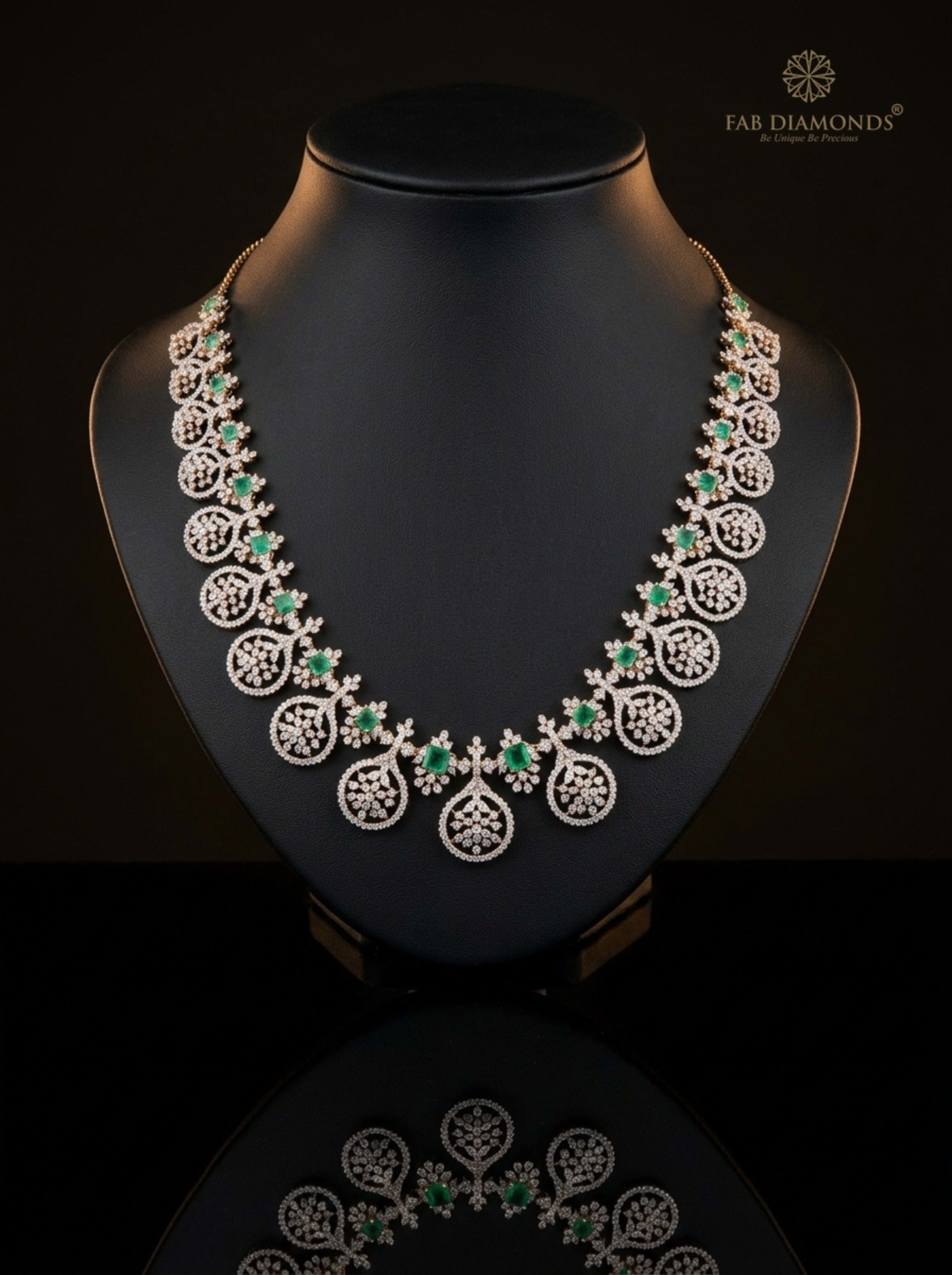 Concentric Diamond Pavé Medallions with Colombian Emeralds on reflective plinth with gold FAB logo