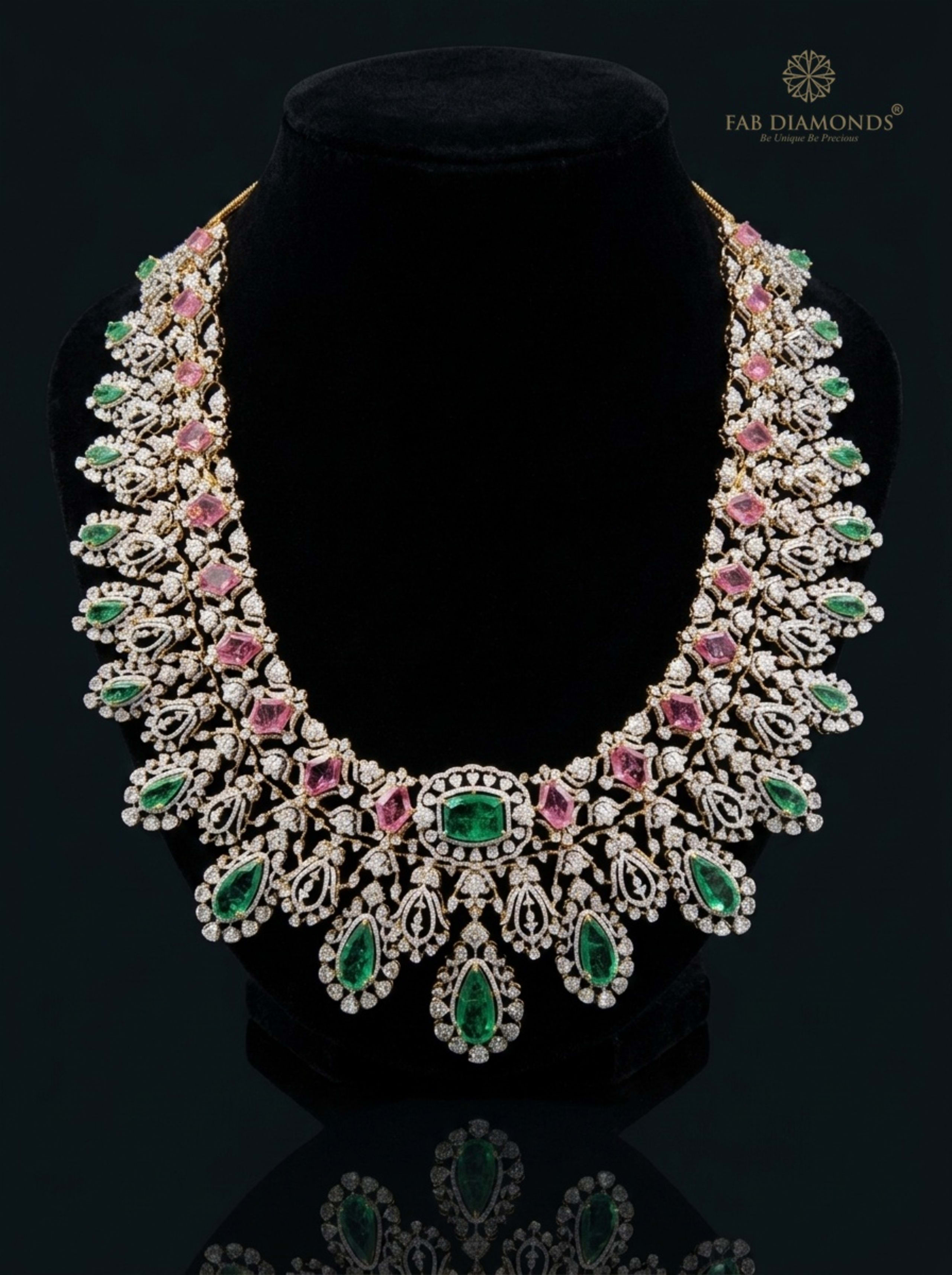 Emerald-Cut Colombian Emerald Haram with Pink Tourmaline Kite Stones on reflective plinth with gold FAB logo