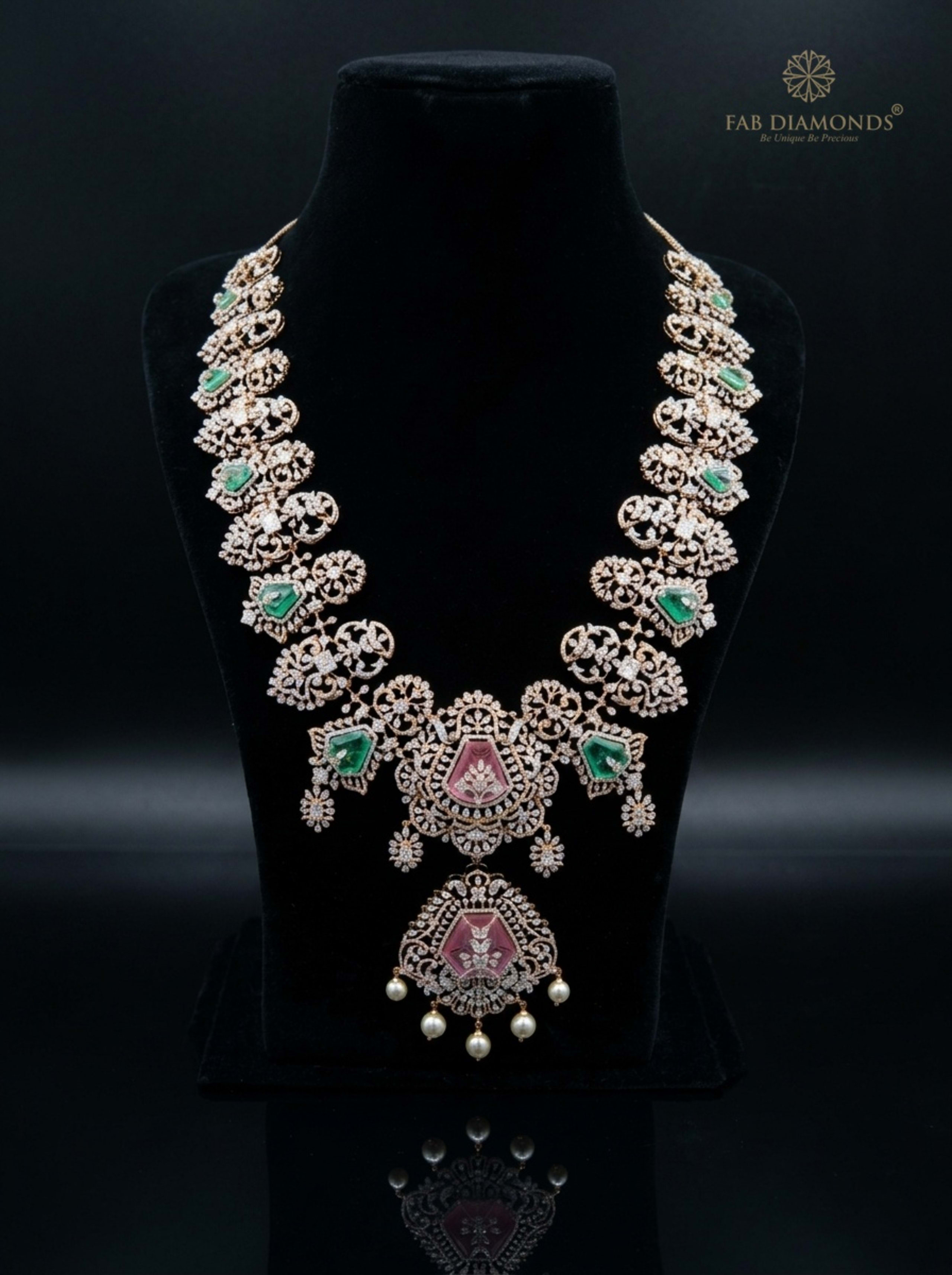 Openwork Diamond Foliate Plate Haram with Shield Emeralds & Pink Pota on reflective plinth with gold FAB logo