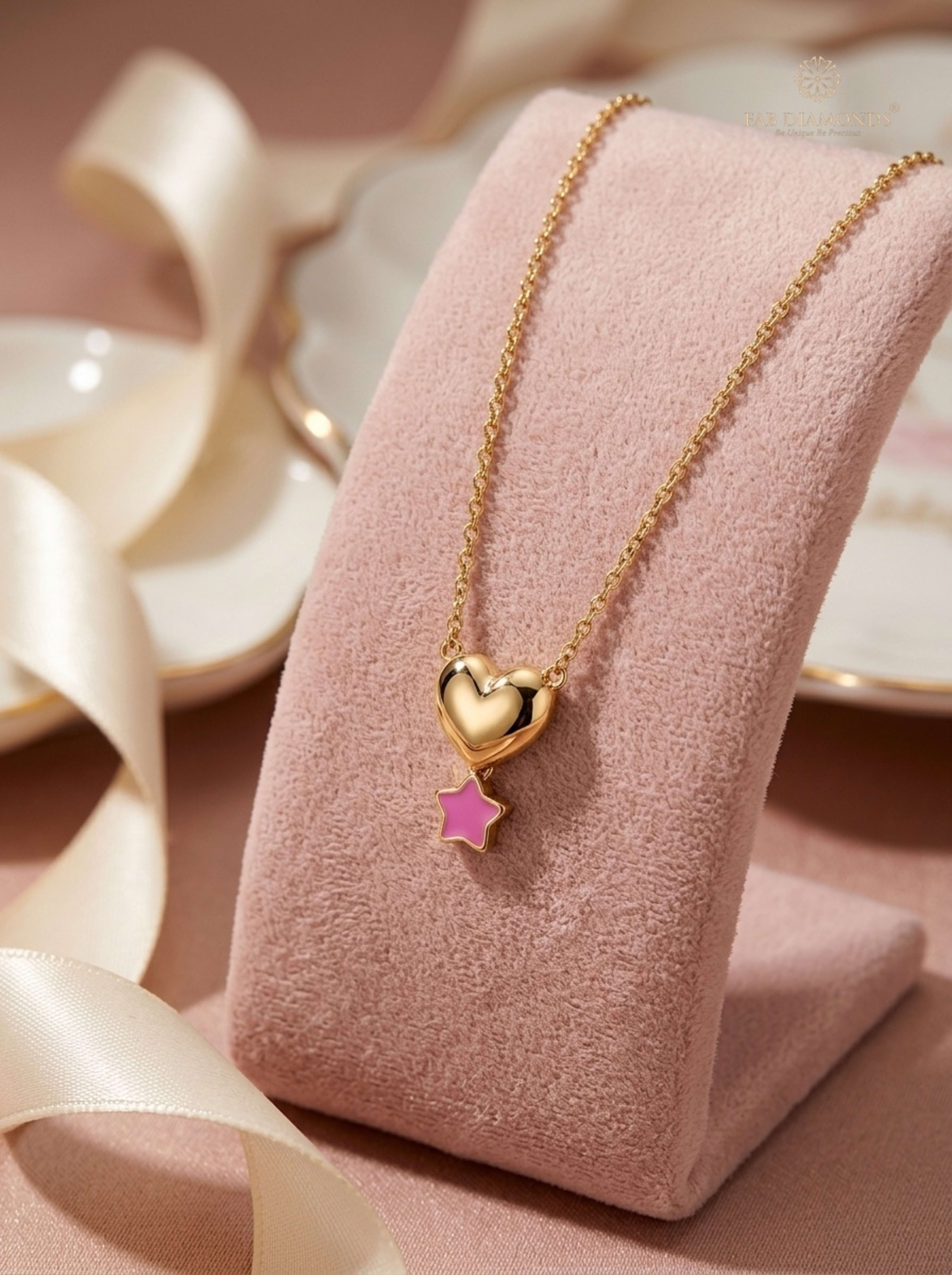 Tara Sculpted Heart & Star Suspended Baby Gold Chain on pink velvet display easel