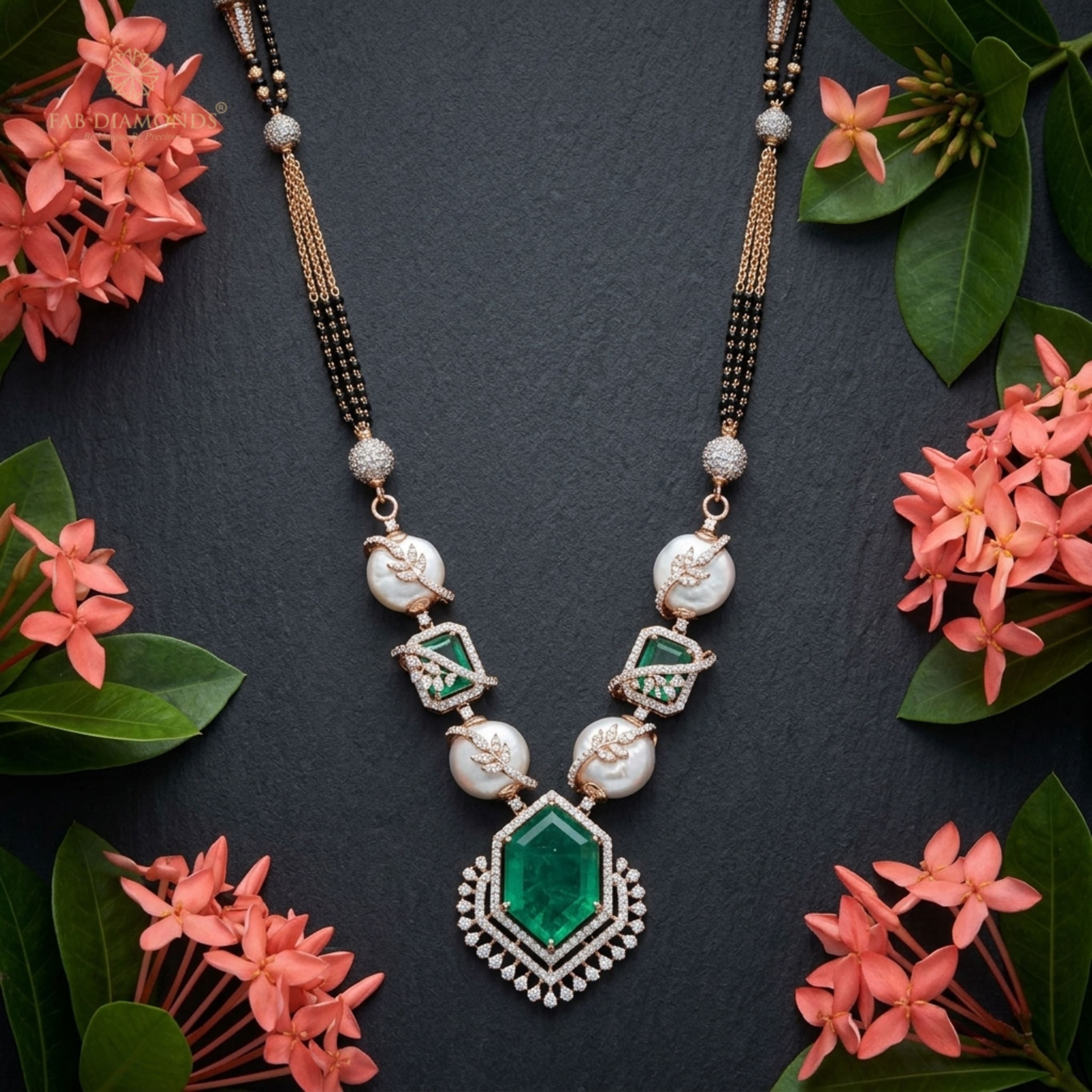 Kasturi baroque coin pearl and hexagonal emerald mangalsutra on dark slate with coral flowers