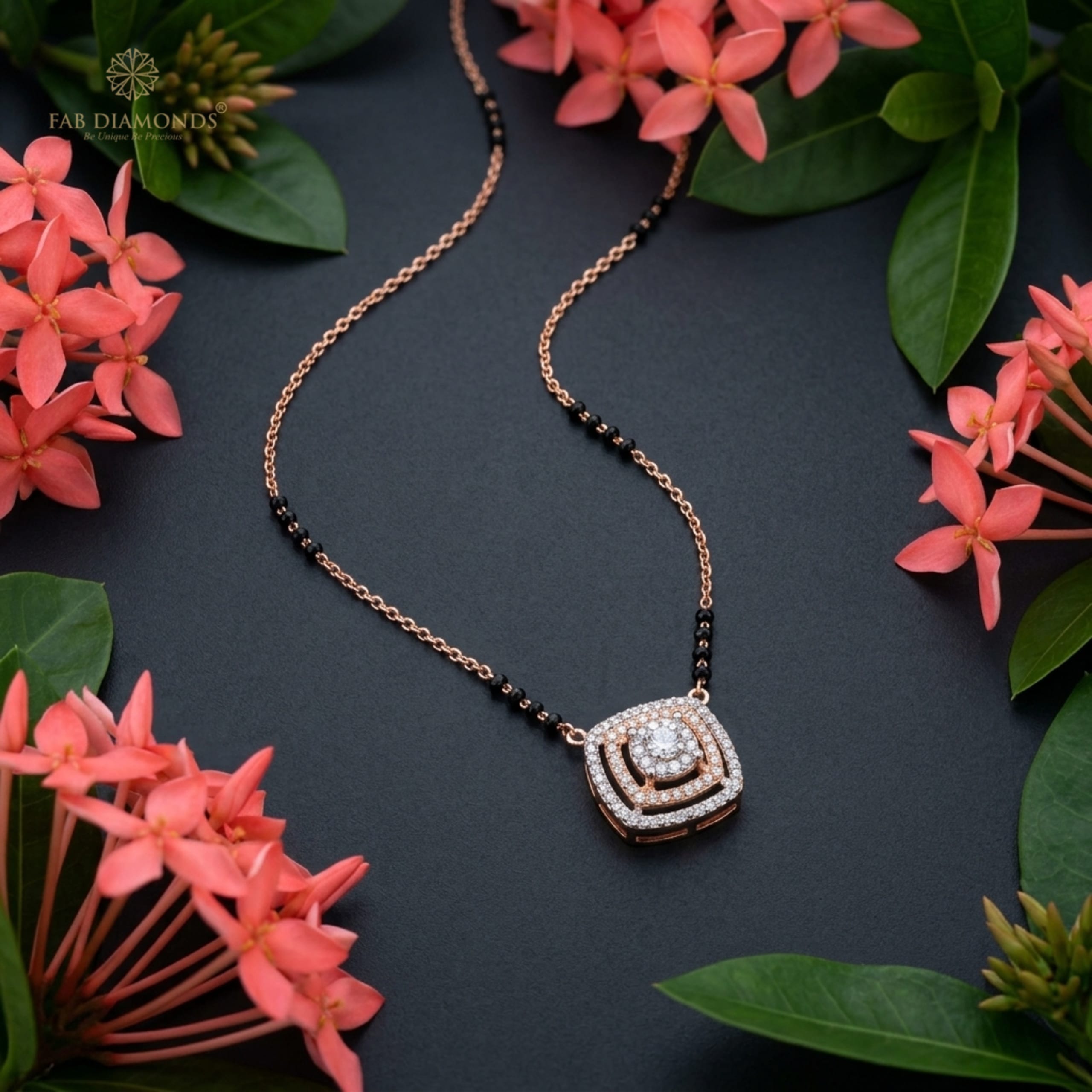 Suhani dual-tone cushion halo diamond mangalsutra on dark slate with coral pink flowers
