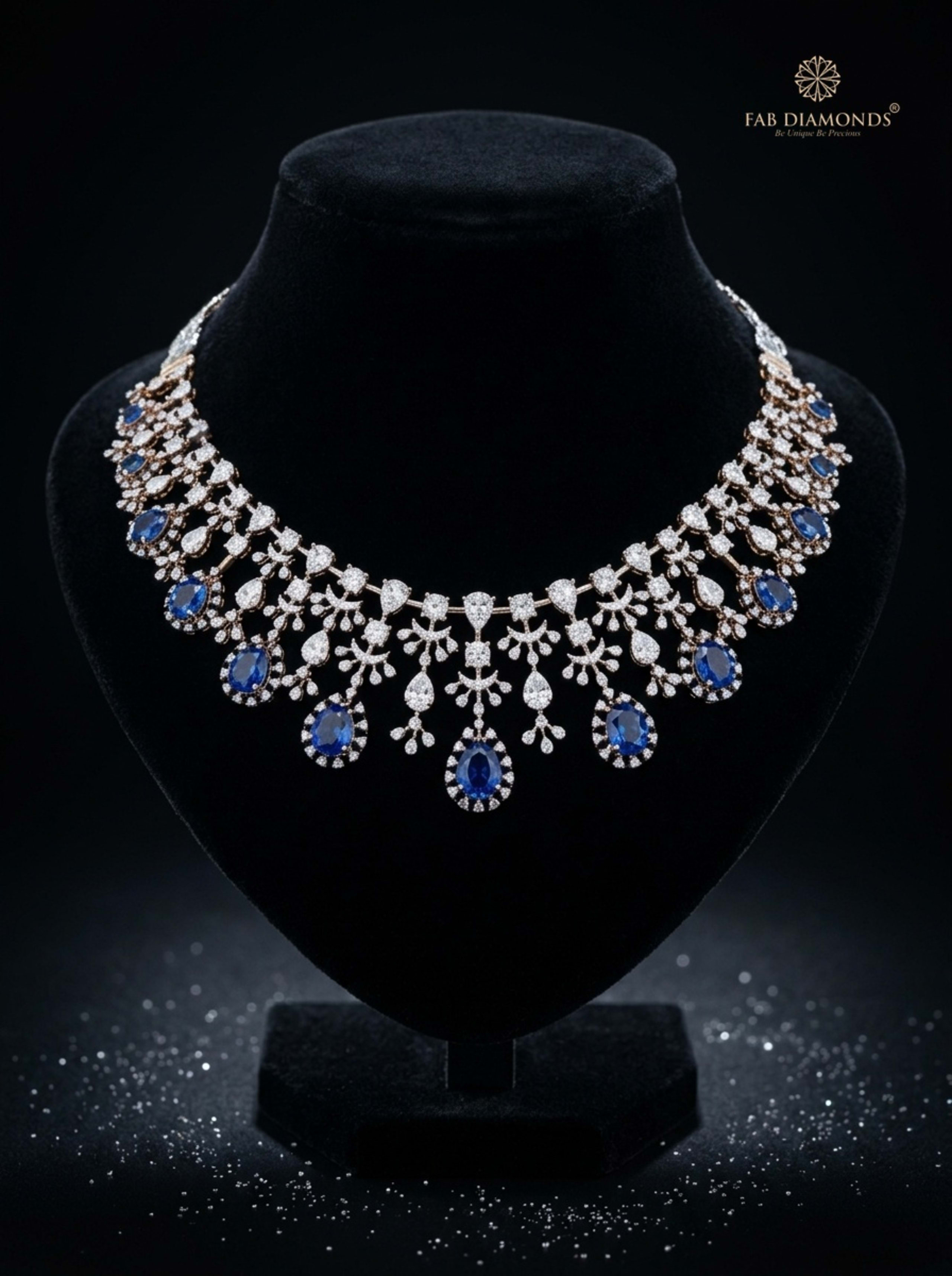 Neelam royal blue sapphire and diamond floral droplet choker on elegant black velvet showcase bust with diamond reflections