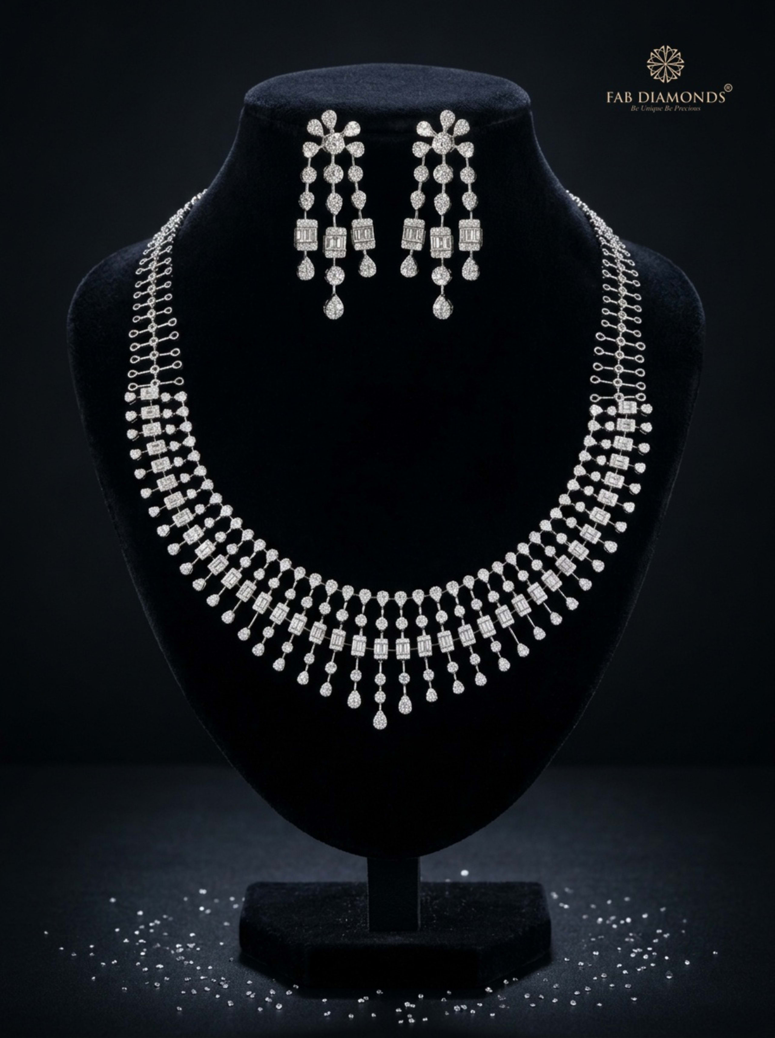 Tarini triple-strand diamond waterfall necklace and matching chandelier earrings on elegant black velvet showcase bust with diamond reflections