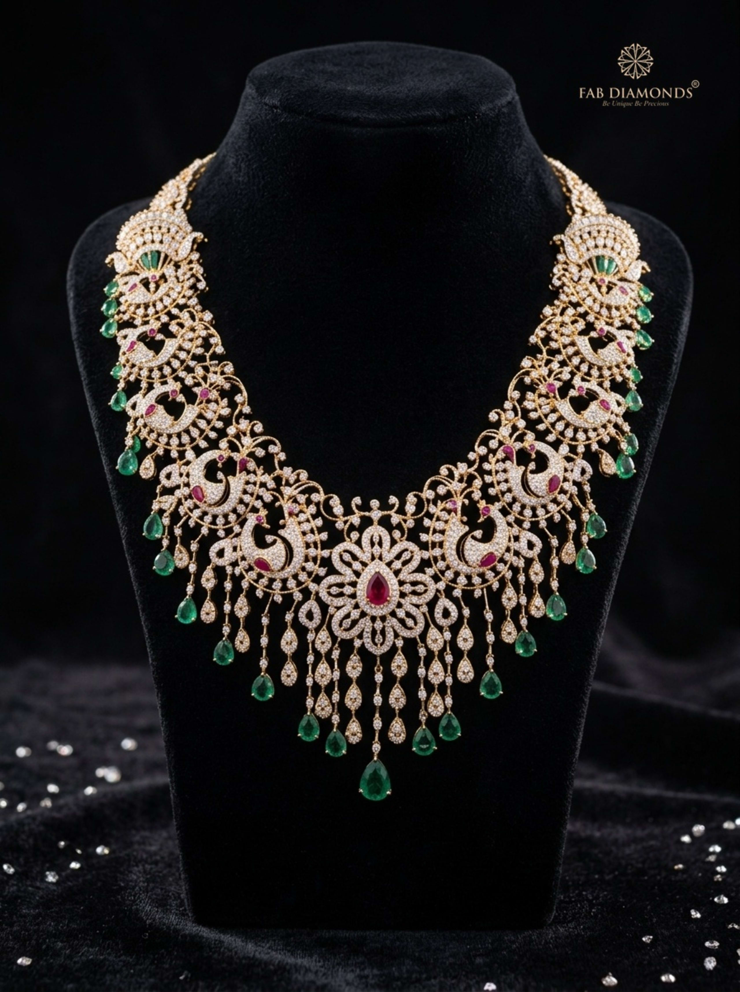 Hamsa royal peacock diamond necklace with ruby center and emerald bead drops flat-lay on champagne silk with river stone