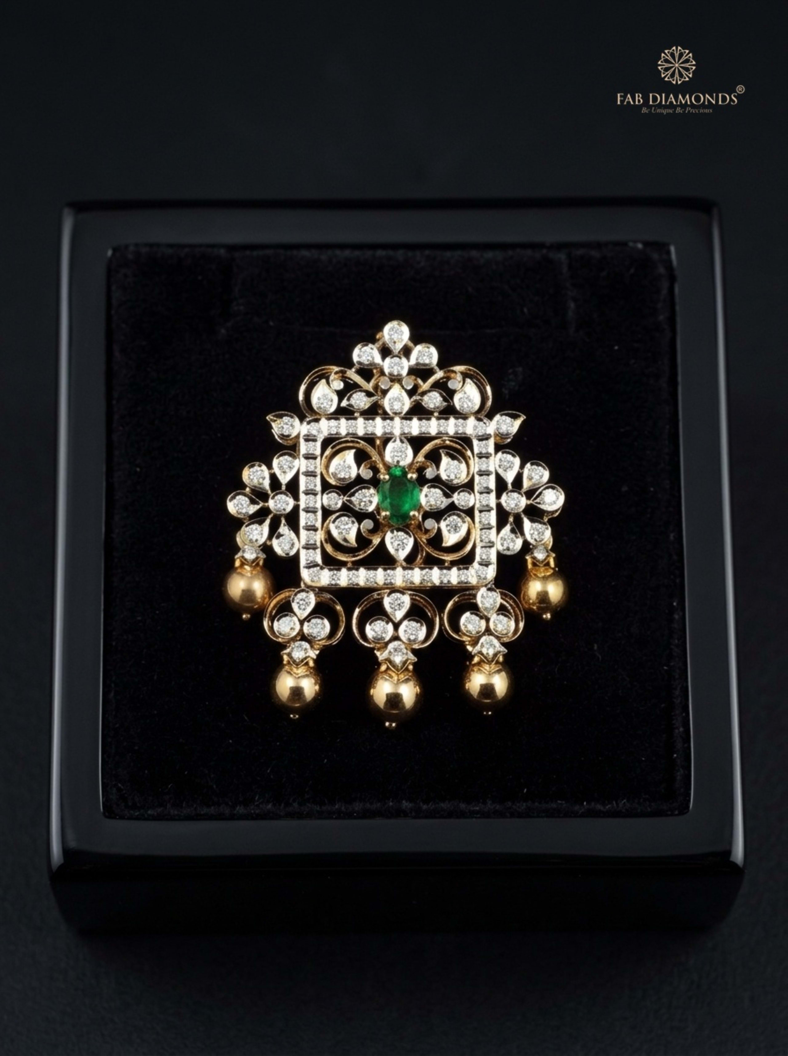 Lavanya radiant teardrop diamond and emerald pendant resting on plush black velvet in glossy black display box