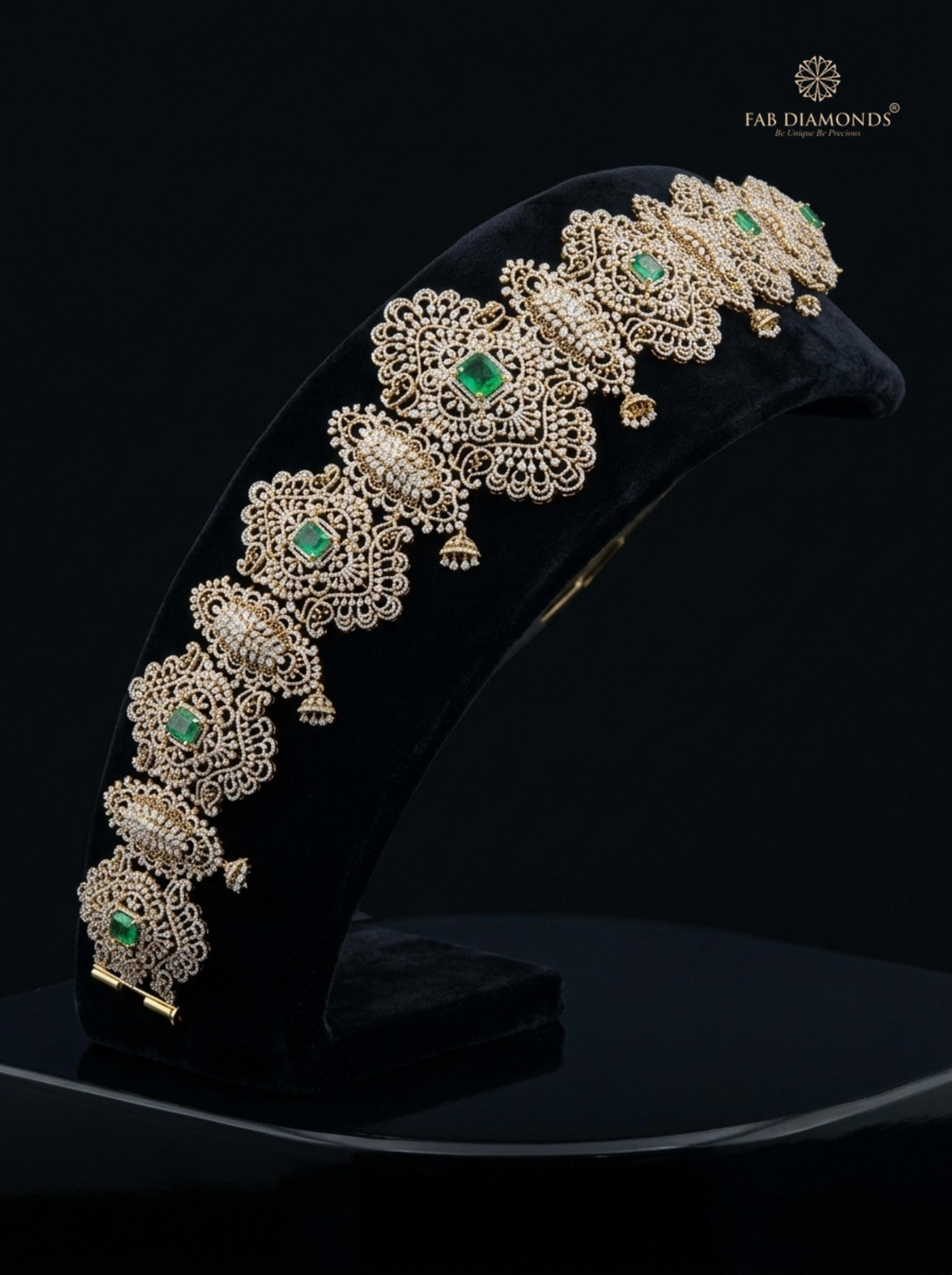 Gayatri 6,600-diamond repeating emerald plaque vaddanam on plum velvet pedestal