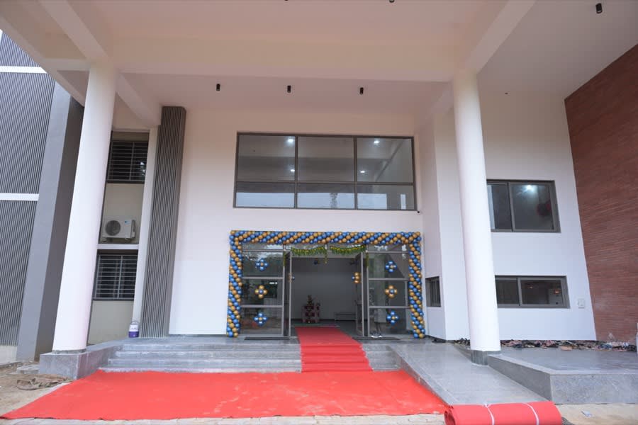 A decorated campus building entrance with a red carpet laid out