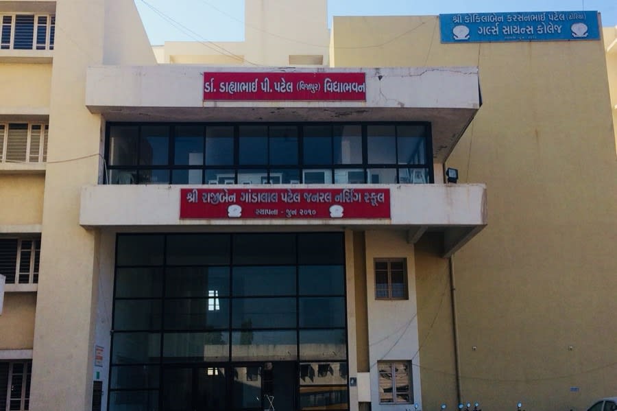 A school building on the SKKM campus with Gujarati signage above the entrance