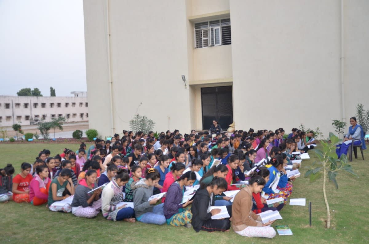 Students of the trust seated together on the campus lawn