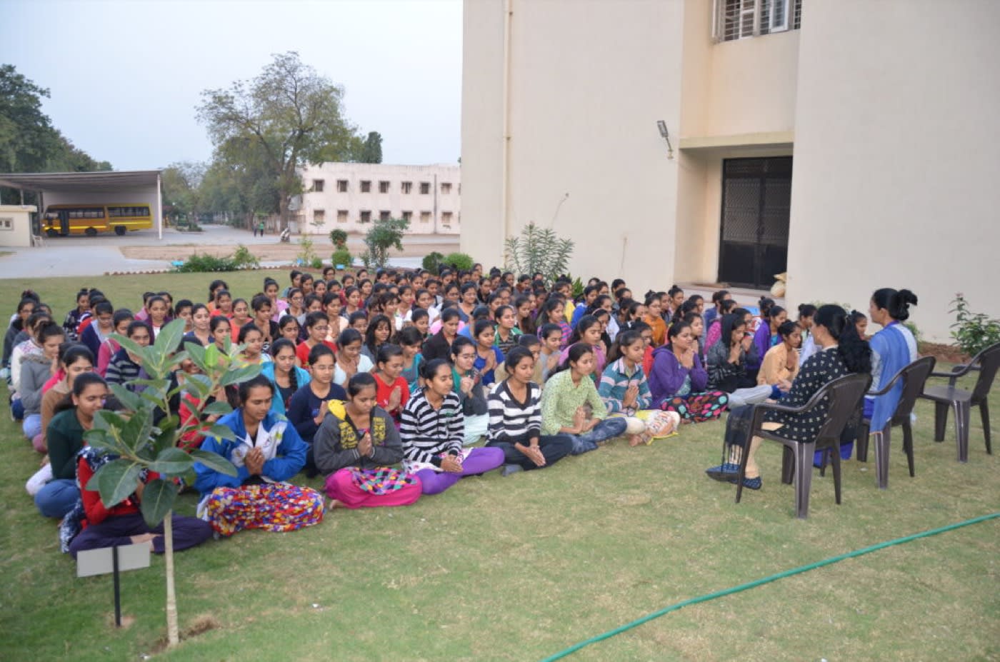 Students of the trust seated together on the campus lawn