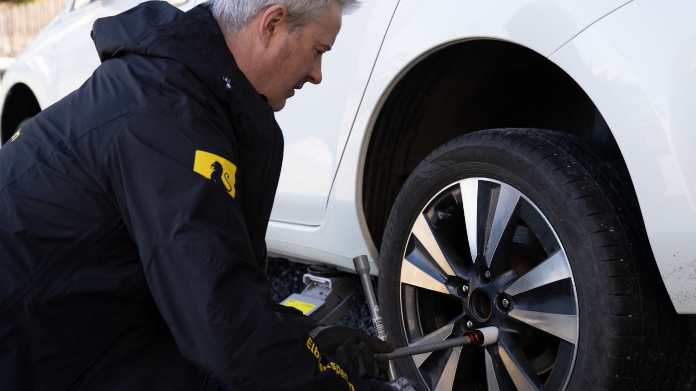 Mann skifter hjul på Nissan Leaf.