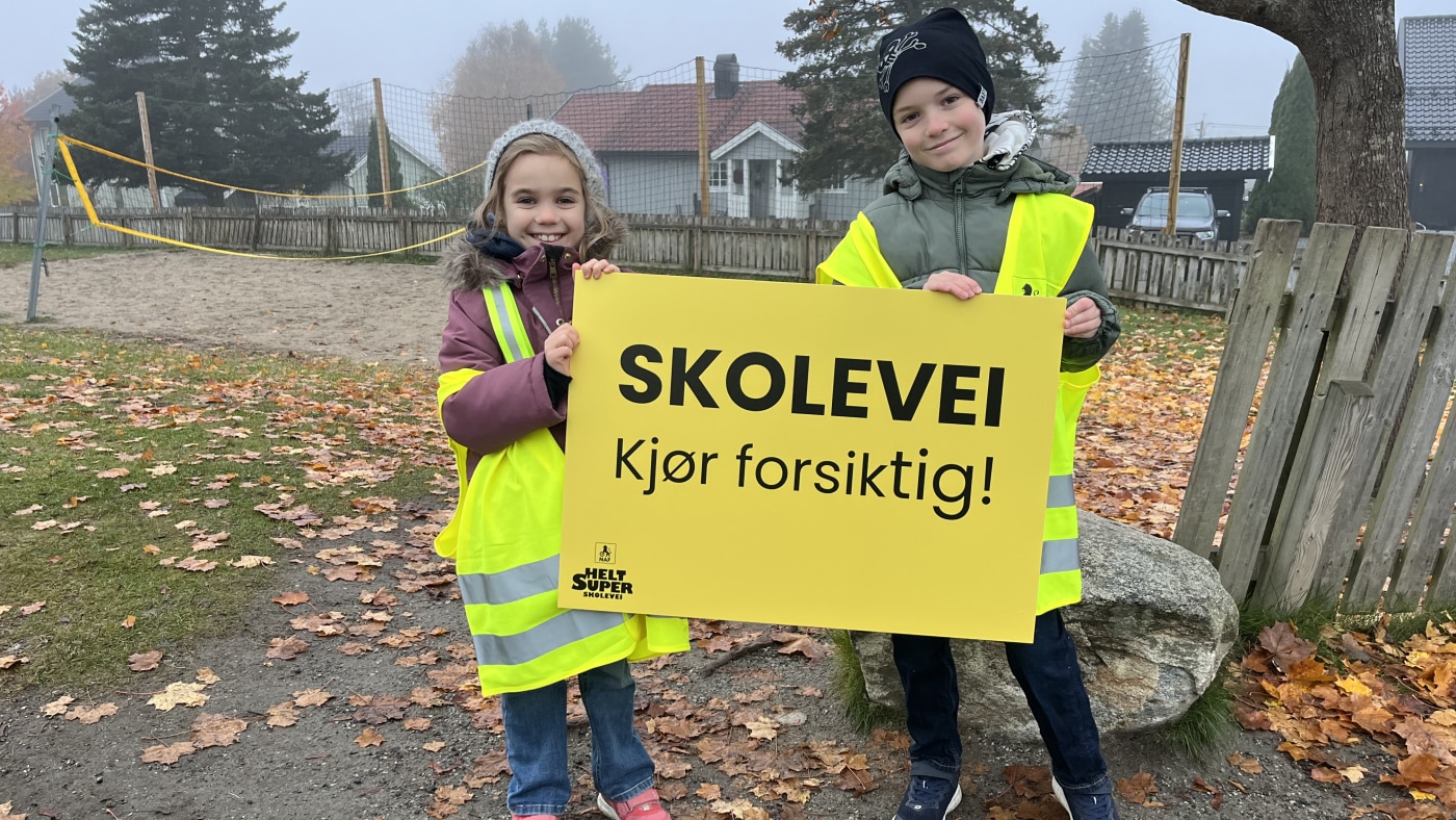 Barn med skilt og refleksvest