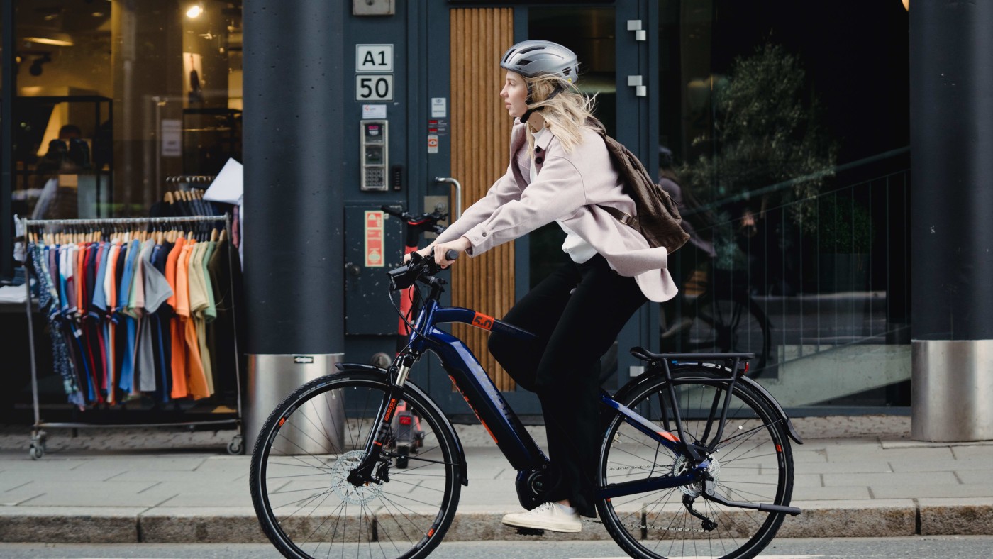 Bildet viser en jente som sykler på veien i Oslo by.
