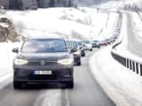 Elbiler kjører etter hverandre i vinterlige omgivelser