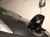 En sort Nissan Leaf som lader i en garasje.