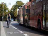 Syklist sykler i sykkelfeltet og buss passerer 