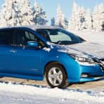 Blå Nissan Leaf i vinterlige omgivelser. 