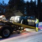 En elbil dras opp på lasteplanet til en bergingsbil.