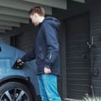 Mann plugger ladekontakt i en elbil