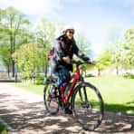 Jente sykler på rød elsykkel i park