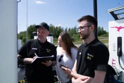 To menn og en kvinne følger med på ladetall