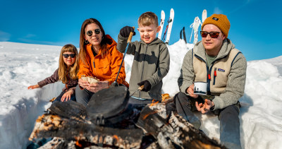 Familie som lager mat i snøen med Hällmark