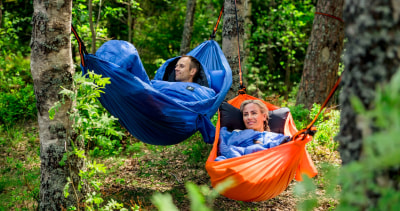 Et par sover i hengekøye i skogen