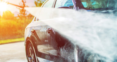 Høytrykkspyler på bil i vårsol