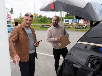 Far og sønn følger med når BMW iX lades.