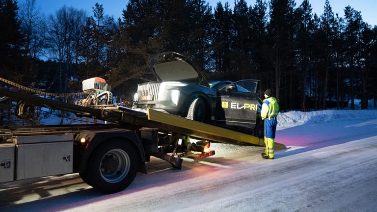 En elbil dras opp på lasteplanet til en bergingsbil.