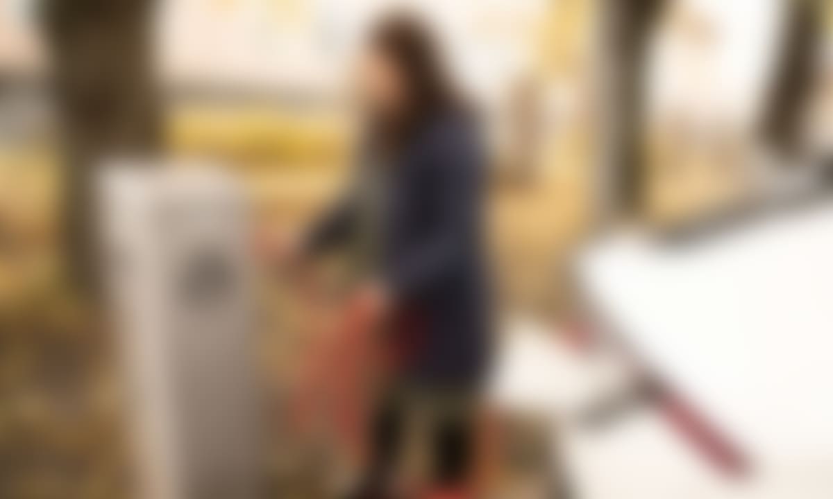 kvinne lader på kommunal ladestasjon
