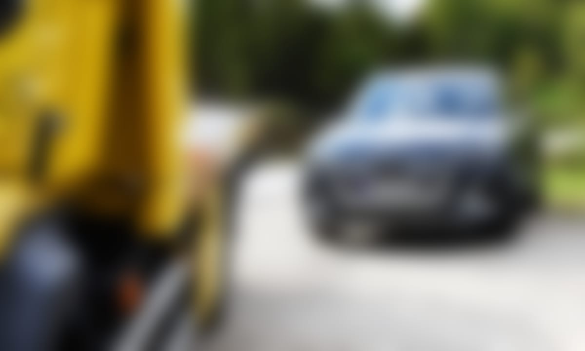 Bil står parkert langs veien, bak NAFs redningsbil