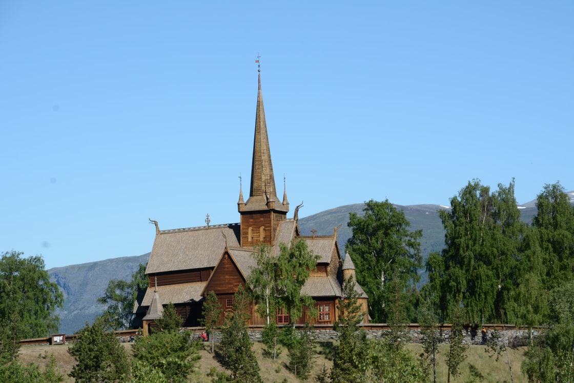Lom stavkirke med grønne trær