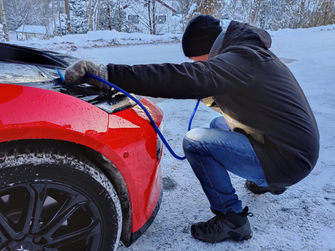 Mann bruker hevert for å få ut spylervæsken.