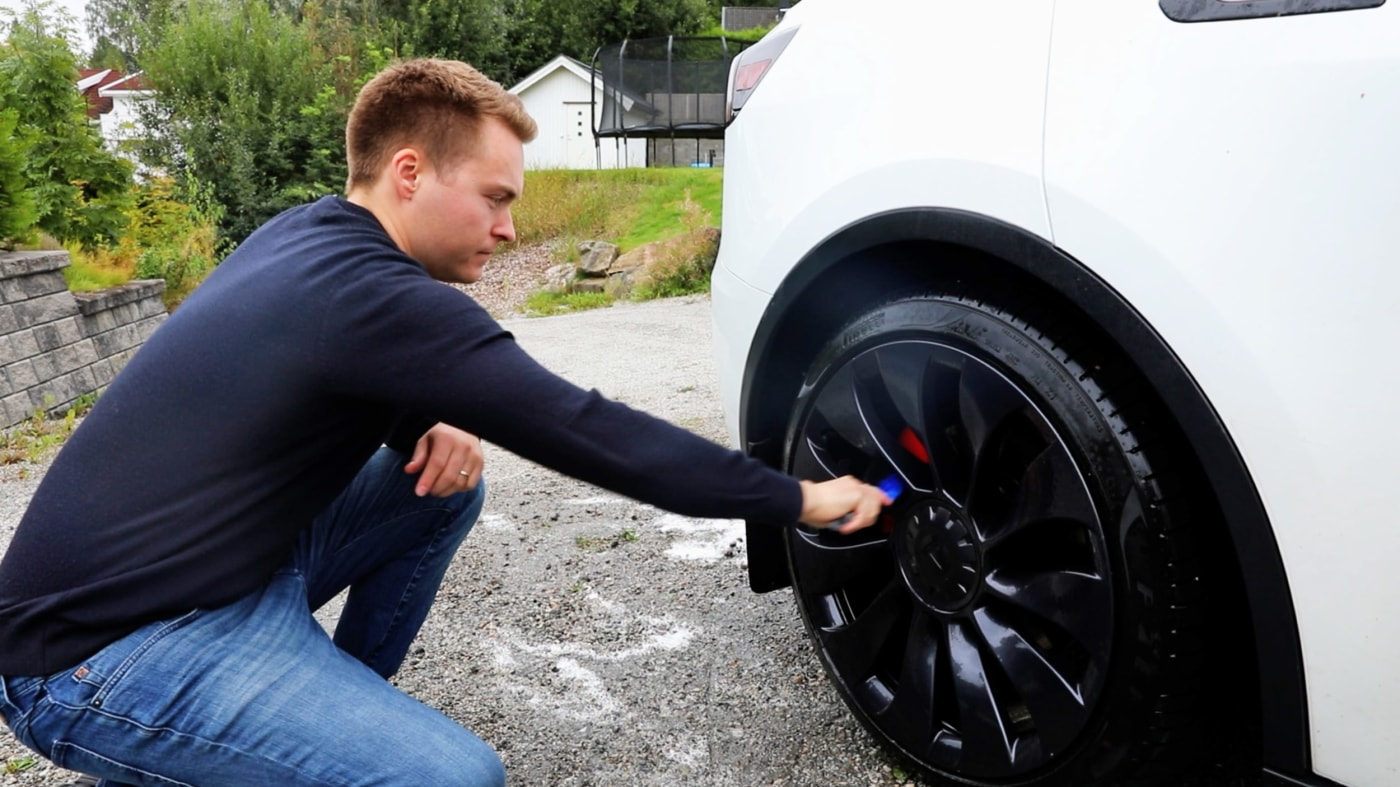 Mann skrubber felger på bil