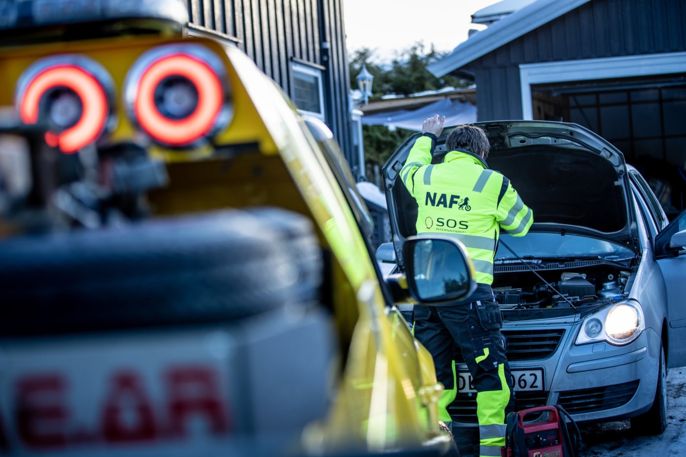 Mann fra NAF veihjelp åpner panseret på bil i innkjørsel