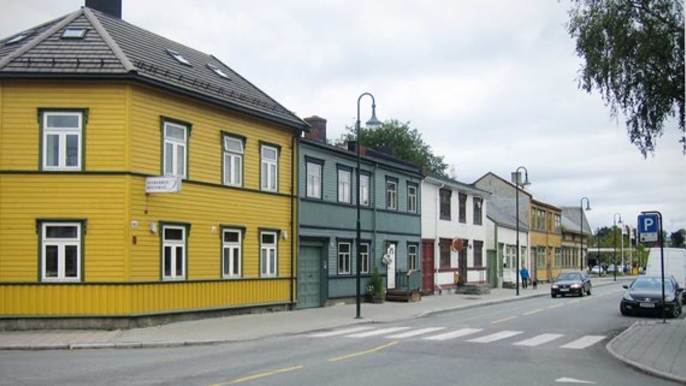 Trehus i rekke, langs en gate. 