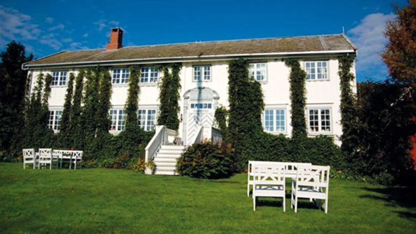 Røkenes Gård. Gammelt hus med eføy klatrende oppover veggene. 