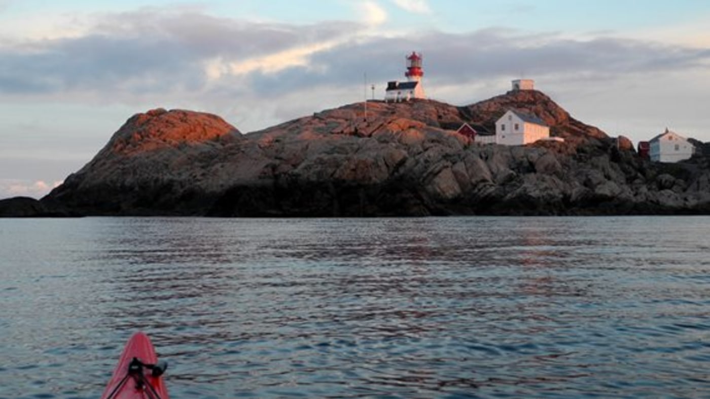 Kajakk på stille vann ved Lindesnes fyr. 