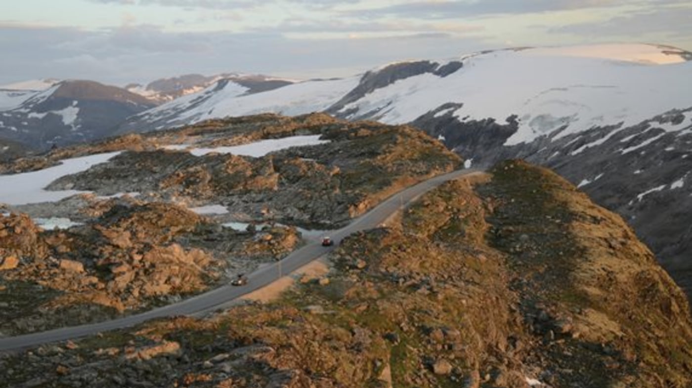 Dalsnibba. Biler på turistveg. Snø på fjelltoppene. 
