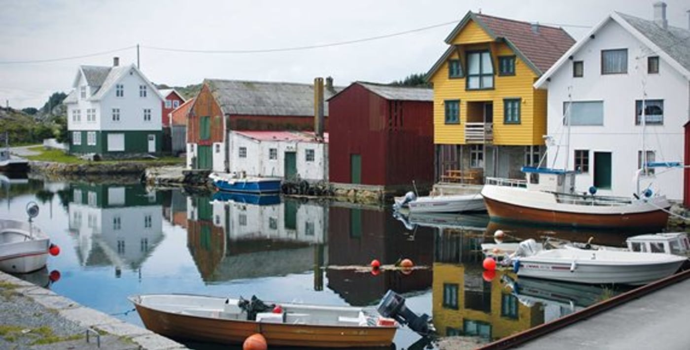 Liten havn med båter og gamle trehus. 