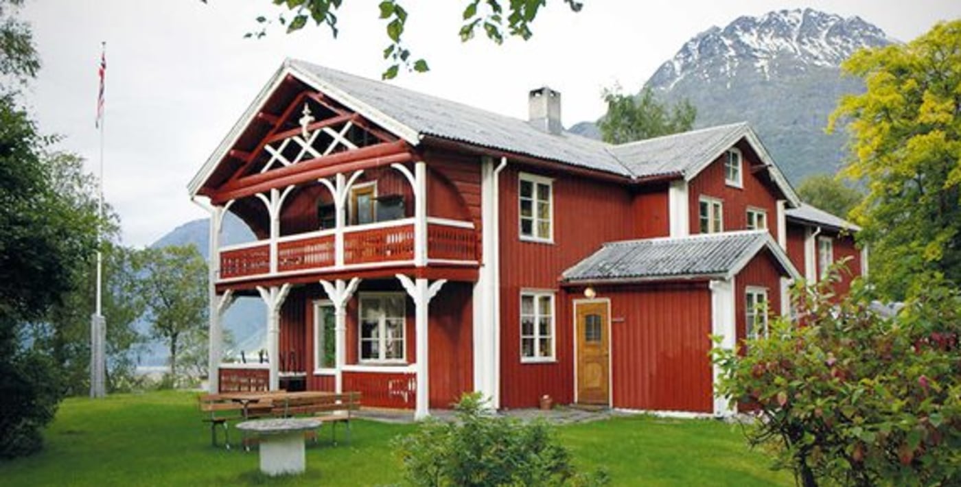 Gammelt hotell med søyler og treskjæring. 