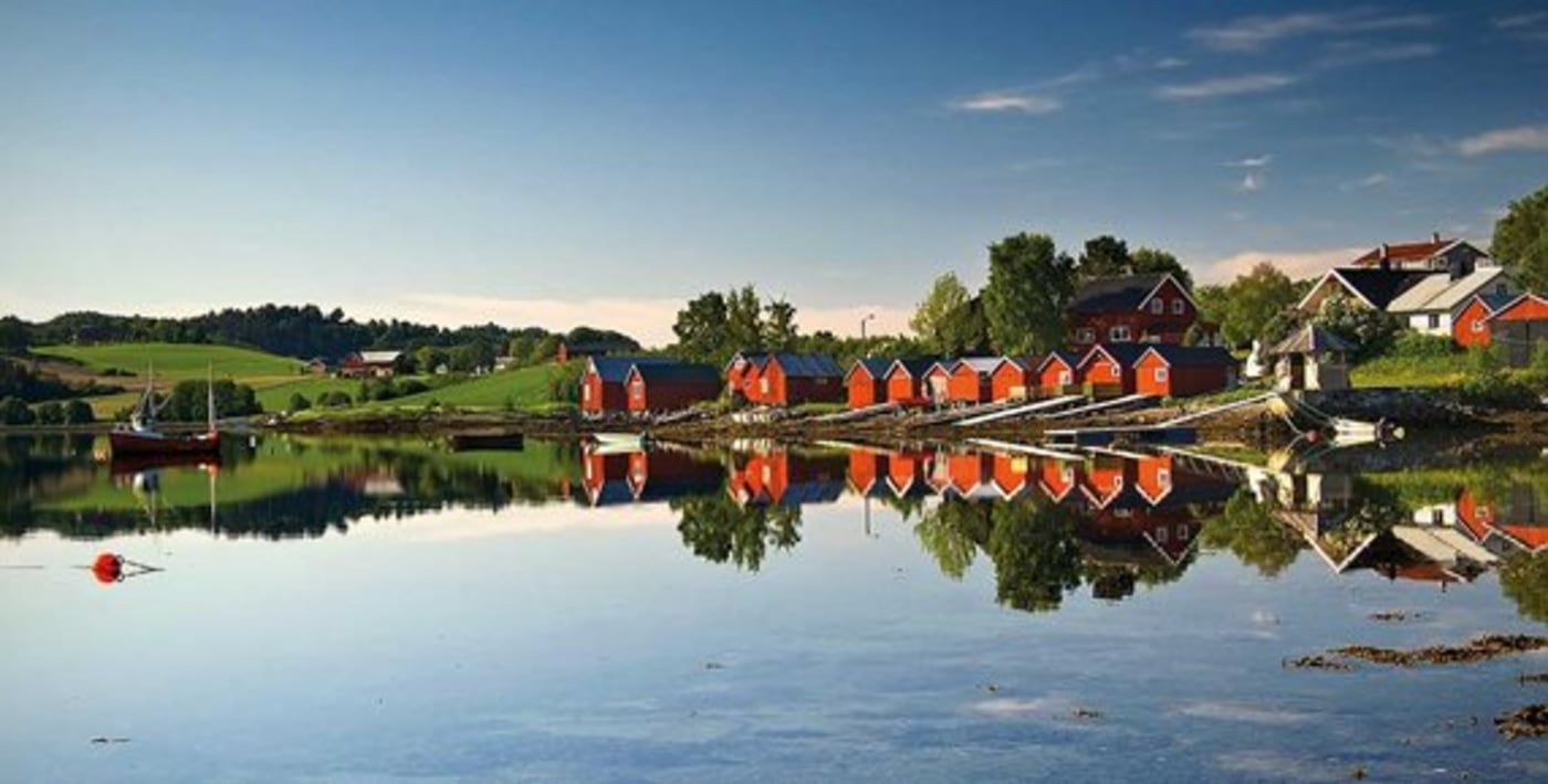 En rekke med naust langs vannet. 