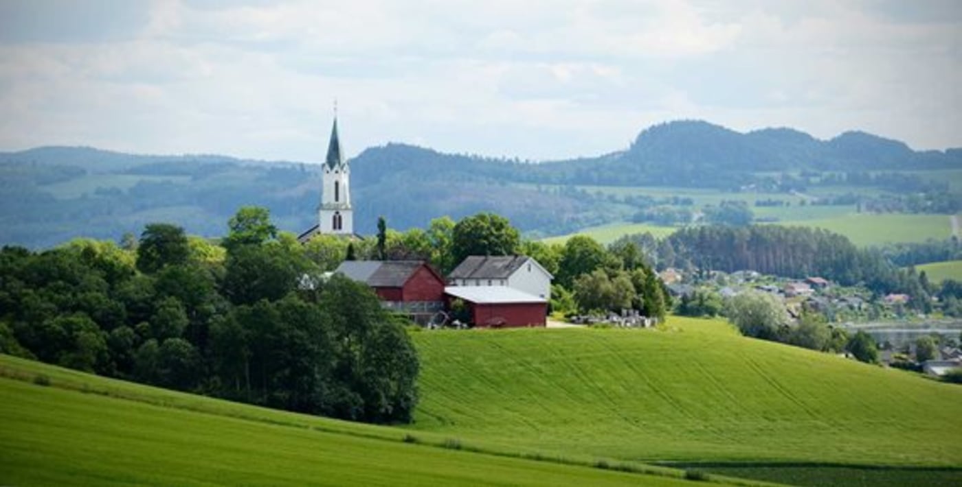 Sakshaug kirke i frodig landskap.