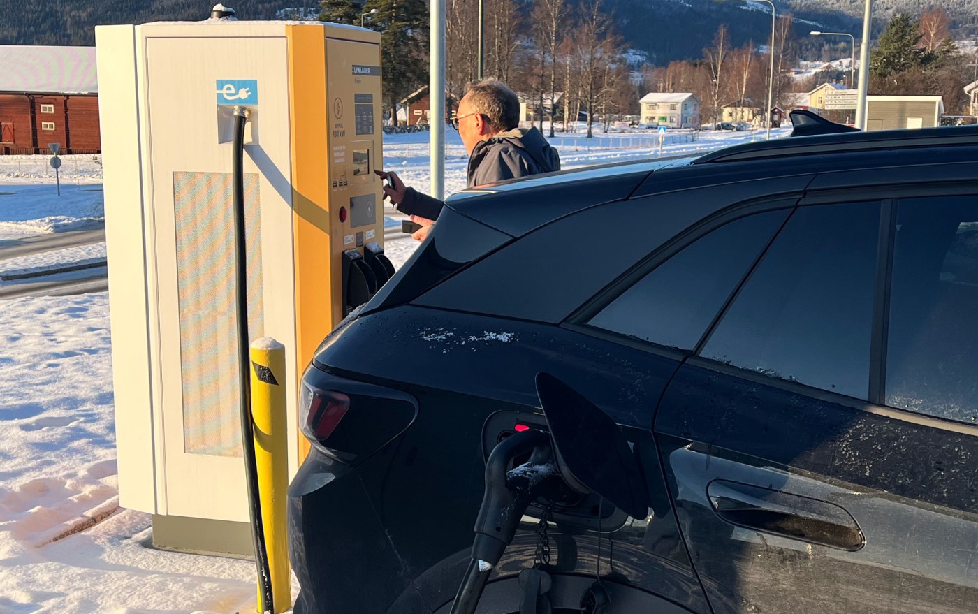 Mann trykker på ladestolpe